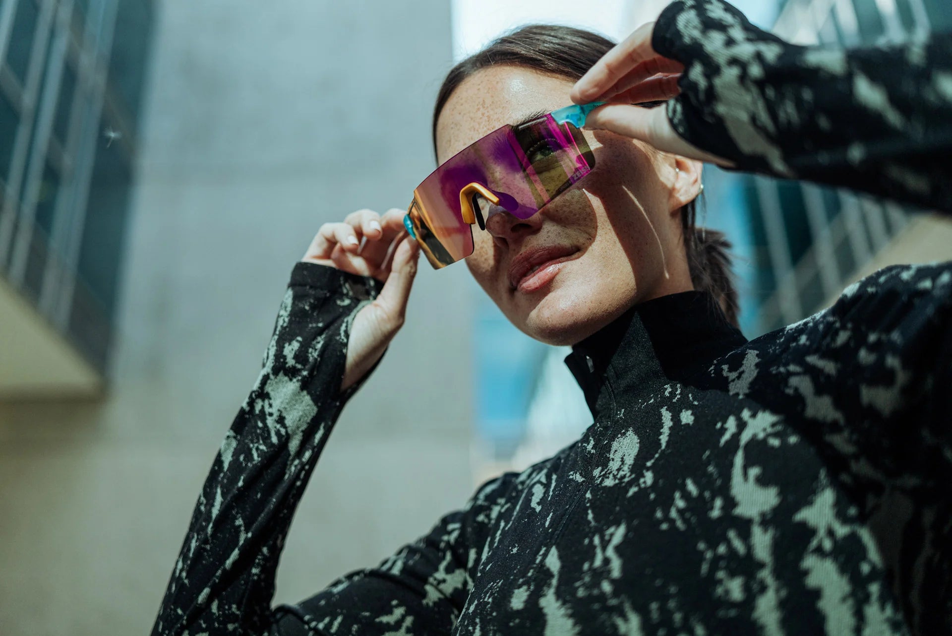 Une sportive porte des lunettes de soleil de sport avec des verres en polycarbonate colorés à l'extérieur