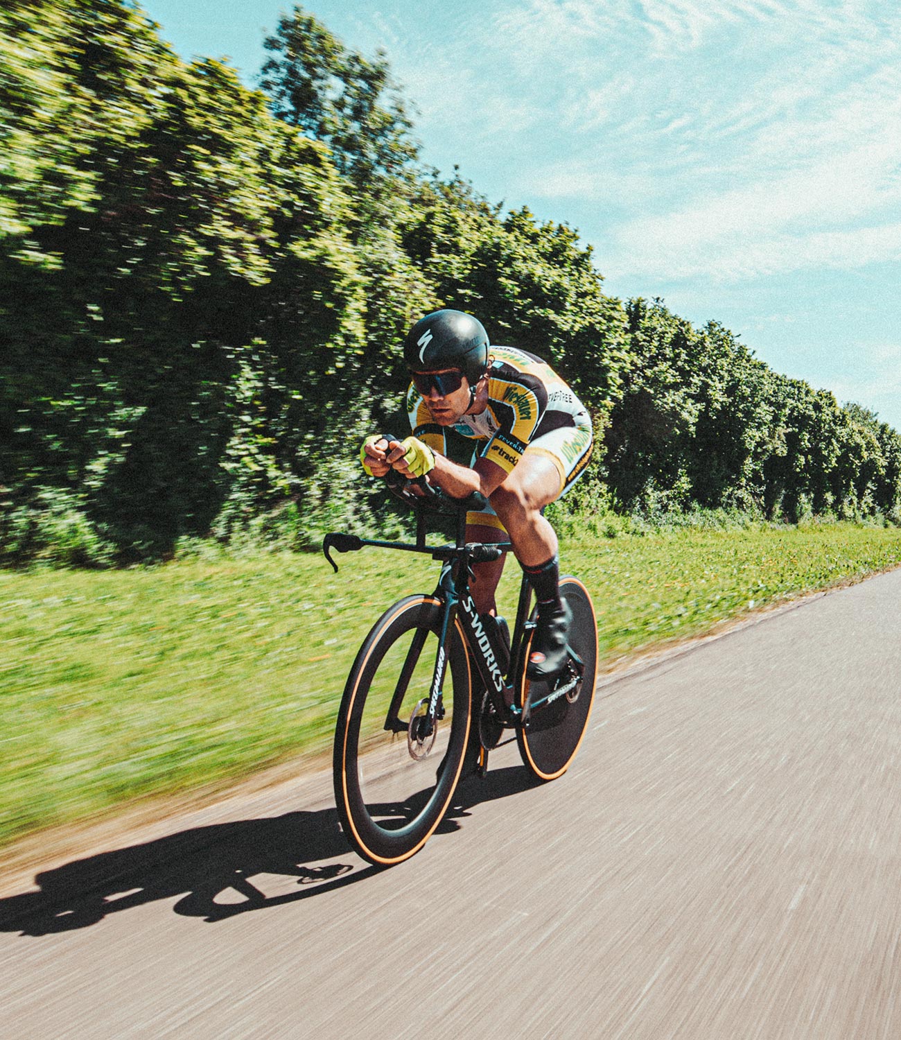 Vélo de course en mouvement sur une route, équipé d'un casque et de lunettes de soleil de cyclisme ; Christoph Strasser © Lex Karelly